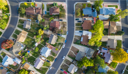 A landscape photo of a suburban neighborhood taken from above featuring a row of houses.