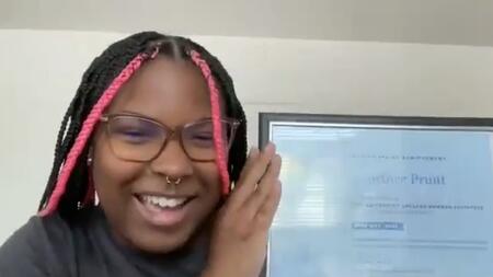 Courtnee Pruitt holds up a certificate over Zoom