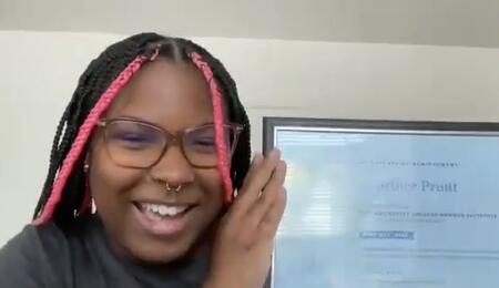 Courtnee Pruitt holds up a certificate over Zoom