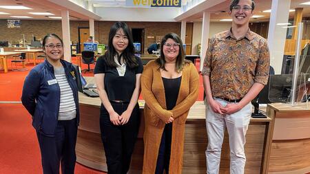 Diana Bachman, assistant director for reference services at the Bentley, stands with Ziyan Zhou, Stephanie Vettese and Clayton Zimmerman in front of the library's welcome desk.