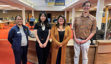 Diana Bachman, assistant director for reference services at the Bentley, stands with Ziyan Zhou, Stephanie Vettese and Clayton Zimmerman in front of the library's welcome desk.