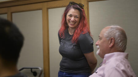 UMSI alum Stephanie Balagot (MSI ’16), project manager in the UX studio at Stellantis, laughs while chatting with clinical professor Charles Severance