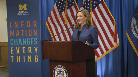 Secretary of State Jocelyn Benson speaks at a podium 