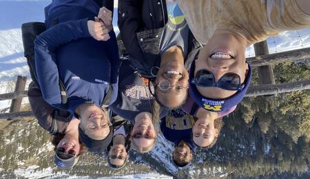 A selfie of eight individuals posing at an overlook in Yellowstone National Park