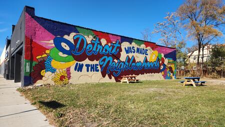 A colorful mural at the corner of Monica Street and McNichols in Detroit that reads "Detroit was made in the neighborhoods." 