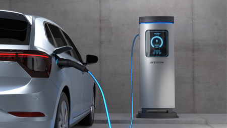 An electric car is plugged into a charging station with a blue cable, parked in front of a wall. 