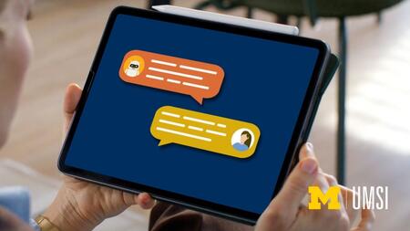 A person holds a tablet displaying a stylized chat conversation between a chatbot and a user. Two colorful speech bubbles, one orange with a small robot icon and one yellow with a person icon, appear on a dark blue screen.