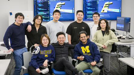 Nine people pose for a team photo, with Chiao Lin in the middle holding an XR headset