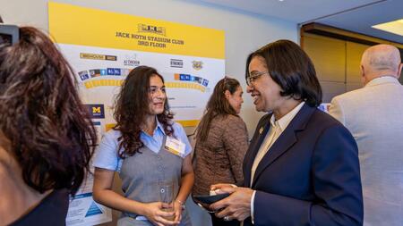 Dhruvi Jagani in conversation with someone at a poster fair