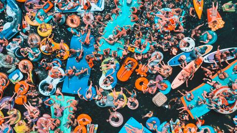 A crowd of people on floating devices in the water