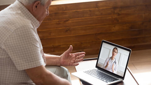 Focused older 80s patient consulting with doctor via video call. Image credit: iStock