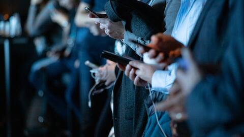 A line of people holding cellphones