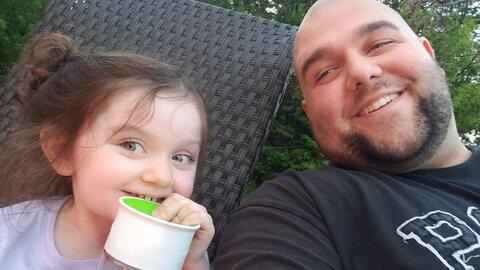 Matthew Wiese smiles next to his child