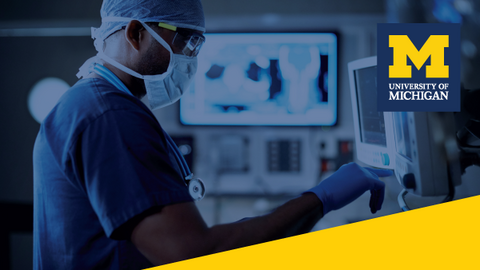 A healthcare professional in scrubs looking at screens