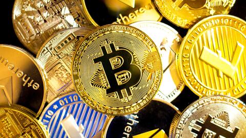 Image shows a loose pile of gold coins representing assorted cryptocurrencies, including Bitcoin, Ethereum and Litecoin. 