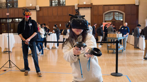 A student in a virtual reality headset models her project. 