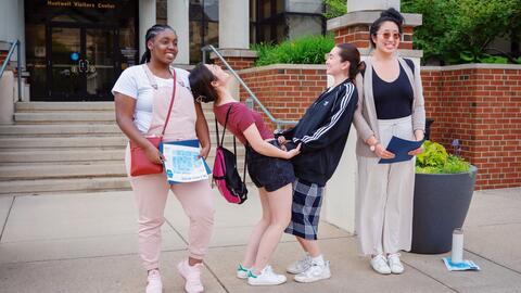 Community college students touring the U-M campus make the Michigan “M” by posing as different parts of the letter in front of the Huetwell Visitors Center.