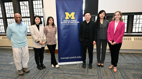 A photo of the Learning Lever Prize winners posing beside a Marsal Family School of Education banner