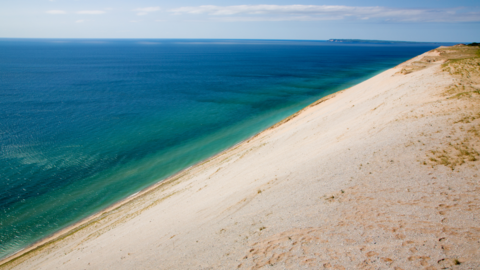 A photo of blue water and white sand at Sleeping Bear Dunes National Lakeshore