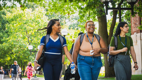 Students walk through the U-M campus near academic buildings on a tour.