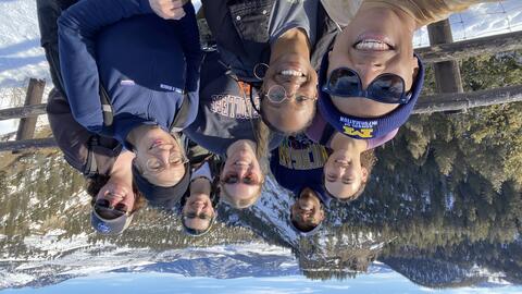 A selfie of eight individuals posing at an overlook in Yellowstone National Park