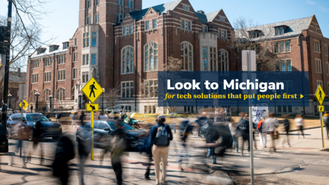 A graphic with a logo that says "Look to Michigan for tech solutions that put people first" over an image of students crossing State Street in front of the Michigan Union on a clear spring day. The students give the illusion of moving very quickly as a result of a long exposure photo, causing them to all have a heavy trail of motion blur.