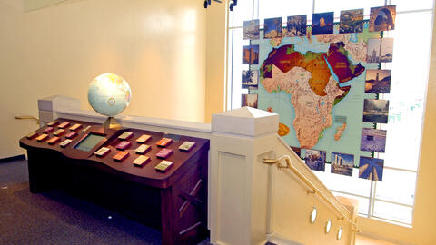 Interactive Arab world map exhibit at the Arab American National Museum, backlit by a floor-to-ceiling window through which natural light streams.