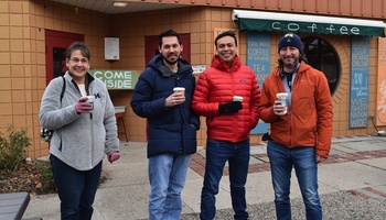 MADS students Stacey Bruestle, Stephen Ontko, David Hernandez and Daniel Best holding to-go coffees outside a coffee shop