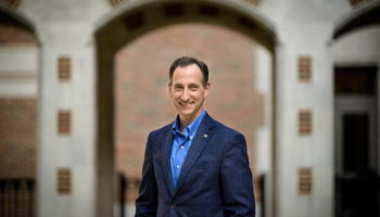 A headshot of Paul Resnick standing in the North Quad courtyard