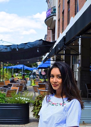 A headshot of Tanisha Afnan outside in front of an outdoor seating area