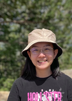 A headshot of Yutong Xie standing in front of a tree