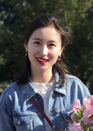 A headshot of Huiran Yi holding a bouquet of flowers.