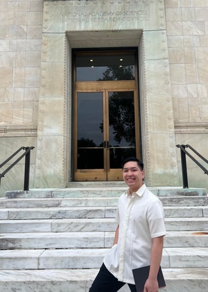 James Dumlao standing in front of a door that has National Academy of Sciences National Research Council carved in stone above it.