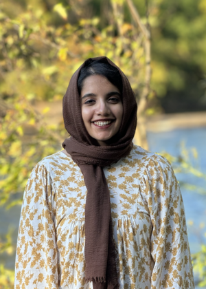 A headshot of Hira Jamshed standing in front of a river