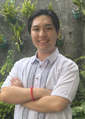 James Dumlao standing in front of a wall of plants.
