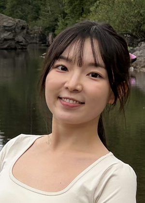 A headshot of Lotus Zhang in front of a lake.