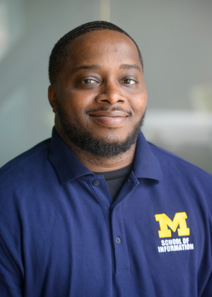 Sharron Criss smiles at the camera, wearing a UMSI polo shirt.