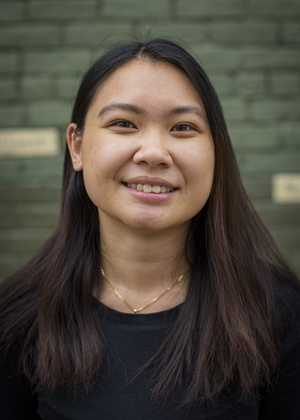 An Doan poses in front of Literati Bookstore's iconic green brick.