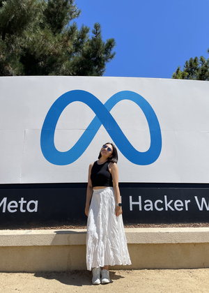 Joanne Huang standing in front of a sign for Meta