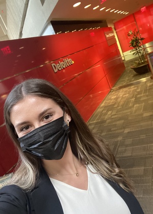 Lilia Duncan next to a Deloitte sign