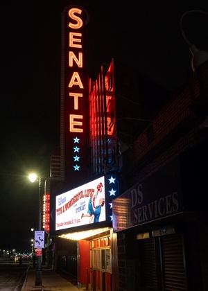 A photo of the marquee at The Senate Theater, glowing red at night.