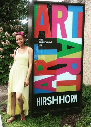 A student stands against the Hirshhorn museum sign