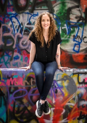 Michaelanne Thomas pictured in an alley with colorful graffiti