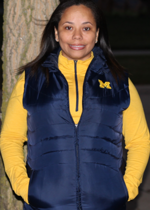 Jacque Adams smiling and wearing a Michigan vest
