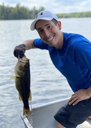 Nick Capaldini smiling as he holds a fish he caught