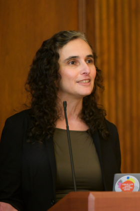 Tanya Rosenblat speaks into a microphone at a podium