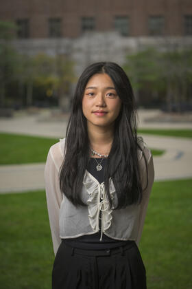 Allison poses under the stone arches of the North Quad courtyard on the U-M campus.
