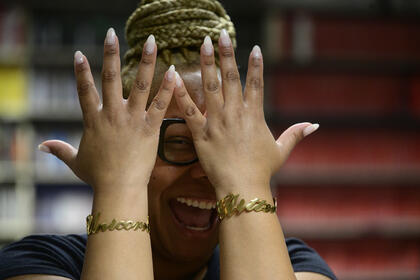 Kishonna holds up her hands in front of her face showing bracelets