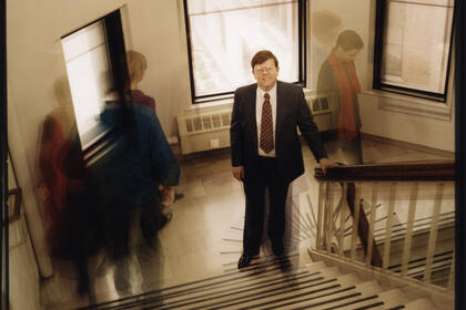 A film photography of Daniel Atkins on a staircase, with other people walking past.