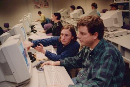 Students in a computer lab working in front of large CRT monitors.